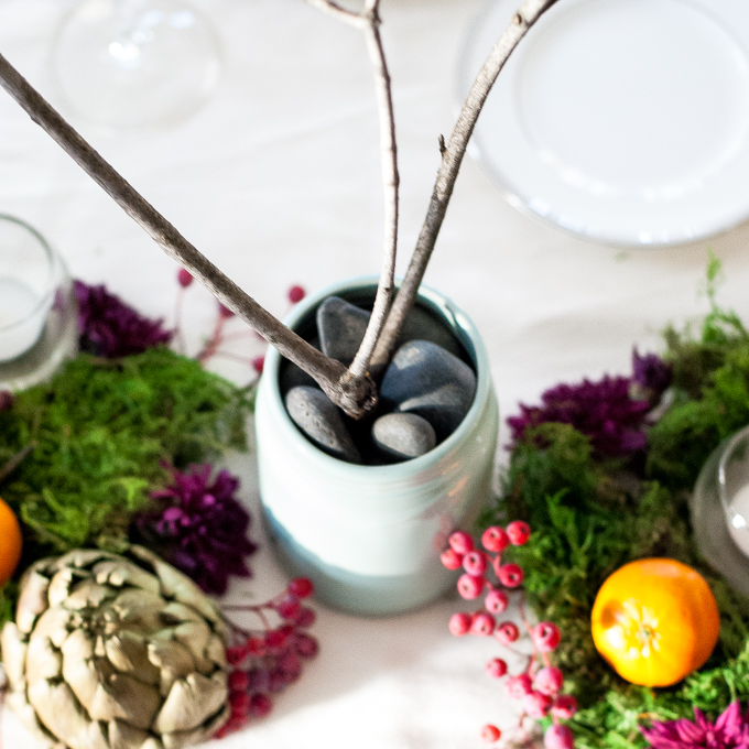 A jewel toned Thanksgiving tablescape with moss, artichokes, clementines, mums, and bare branches. Fresh, chic, and dramatic but still so simple to assemble!
