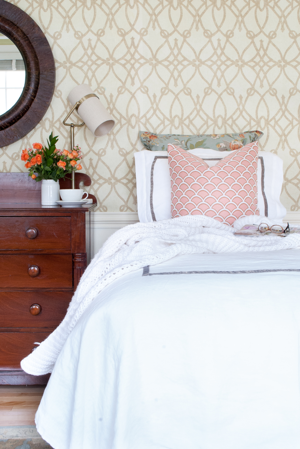 Classic bedroom with white duvet, soft graphic wallpaper, dusty blue and blush accents.