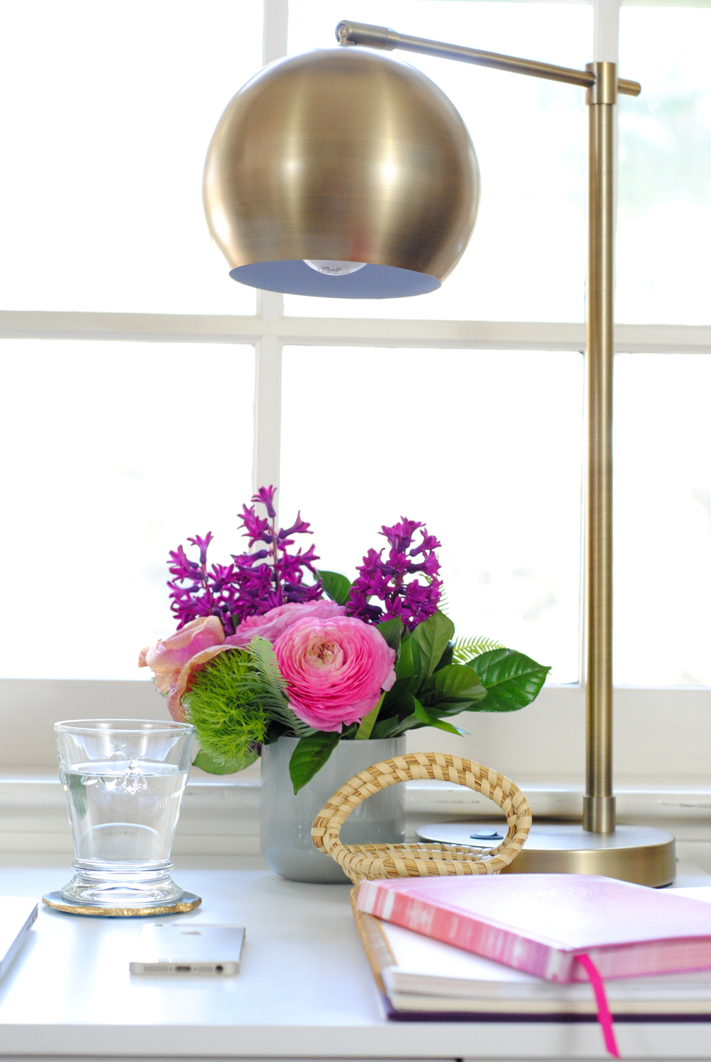 Pretty desk nook with white parsons desk, brass task lamp, lucite and gold accessories