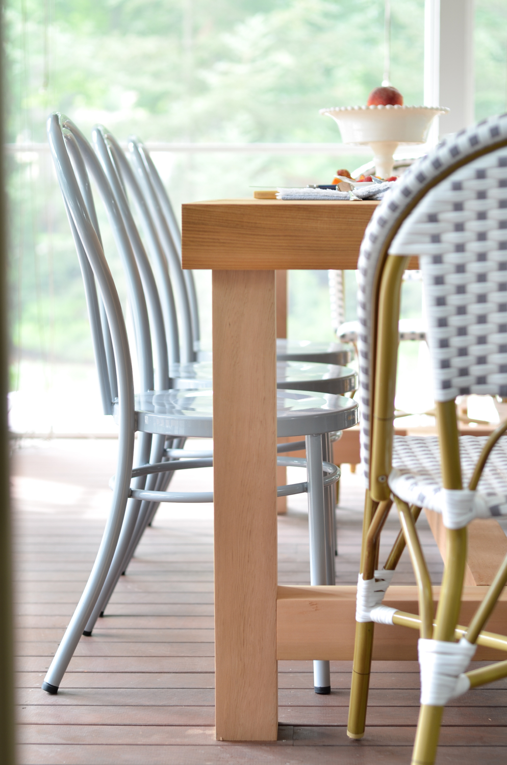 Metal bentwood chairs (that come in nine different colors!) and a DIY outdoor dining table inspired by a $4000 Restoration Hardware table are the perfect finishing touches to this totally gorgeous screened porch!