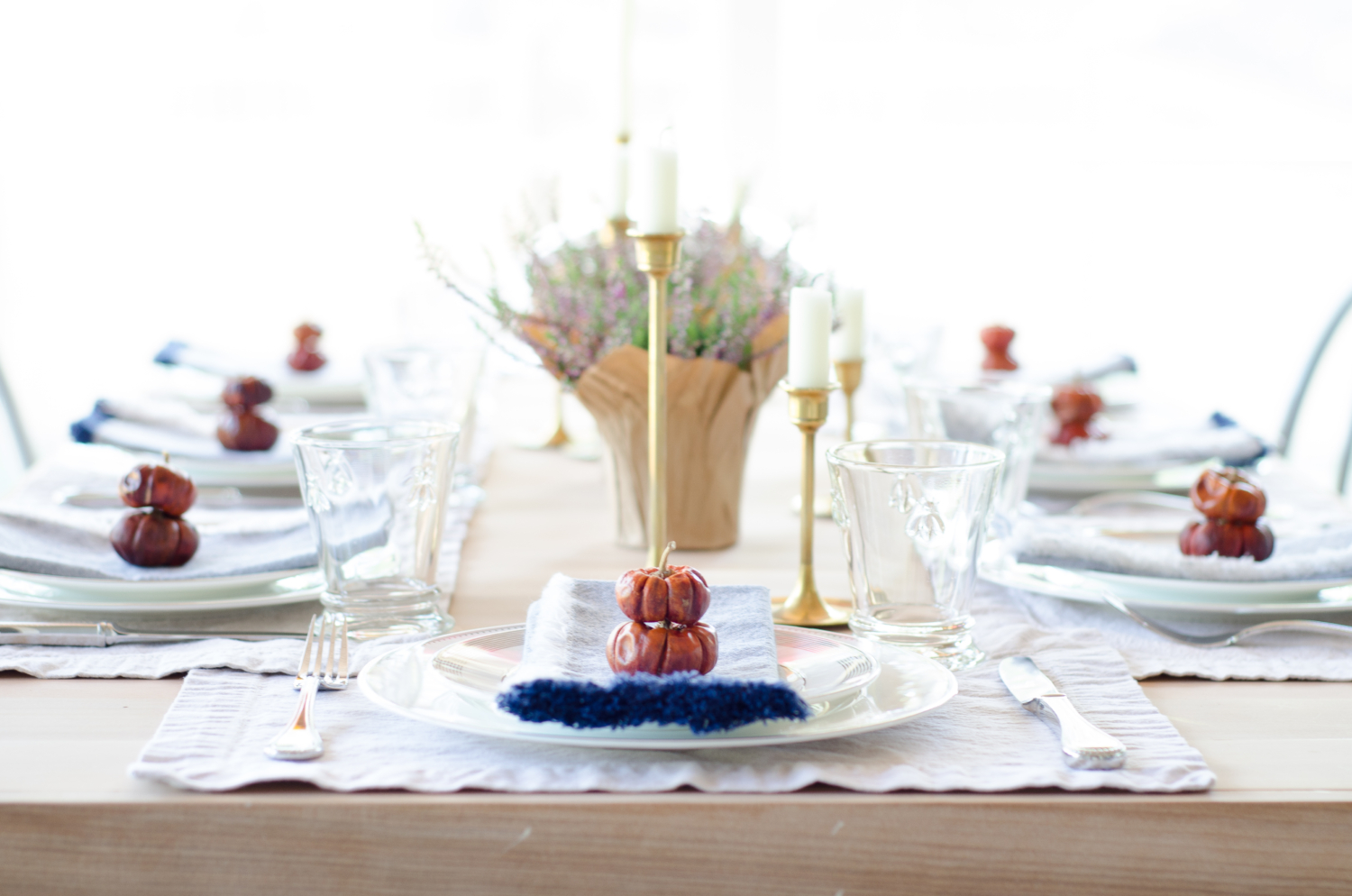 Simple, classic fall table with brass, navy blue, white, purple, and deep orange.