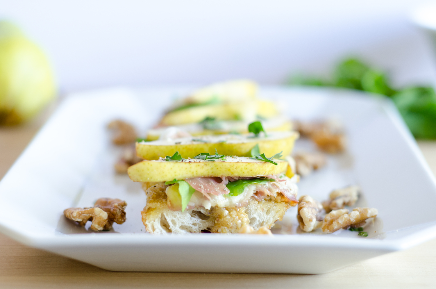 Crazy good fall appetizer - crostini with sweet and salty walnut pesto, pears, prosciutto, and Havarti cheese. To die for!!