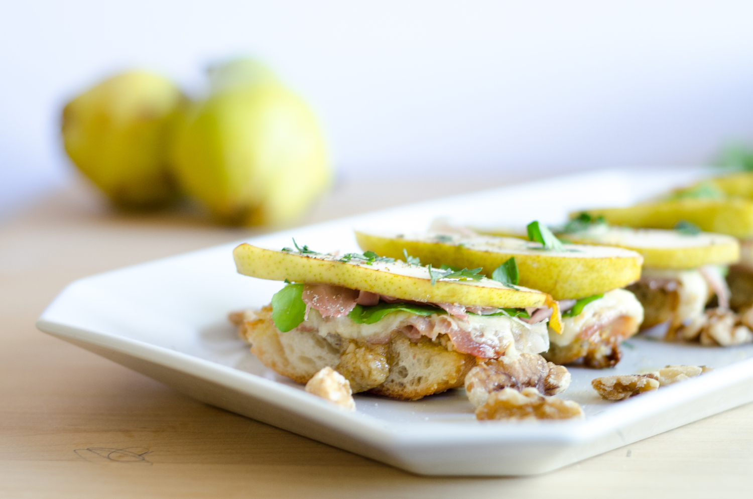 Crazy good fall appetizer - crostini with sweet and salty walnut pesto, pears, prosciutto, and Havarti cheese. To die for!!