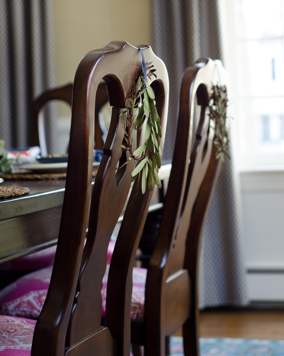 Easy Christmas decorating - miniature wreaths hung on the backs of dining room chairs