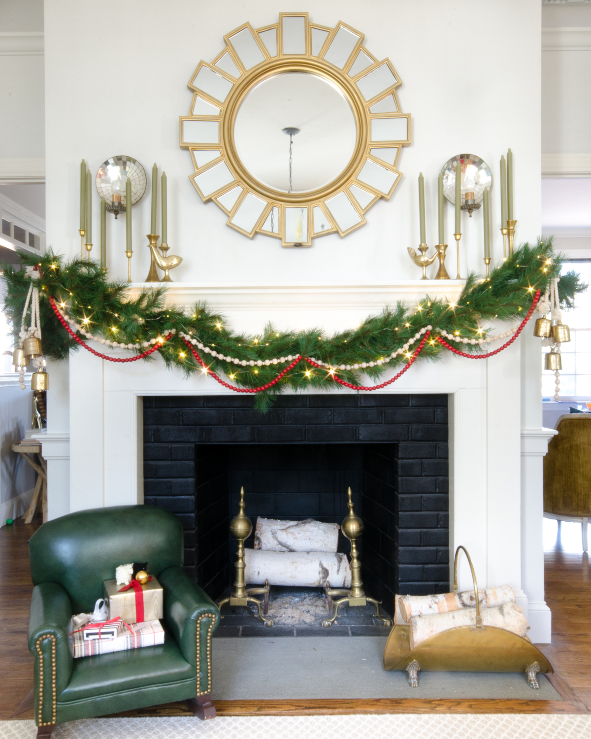 Classic Christmas mantle with greenery garland, red beads, and gold bell clusters.