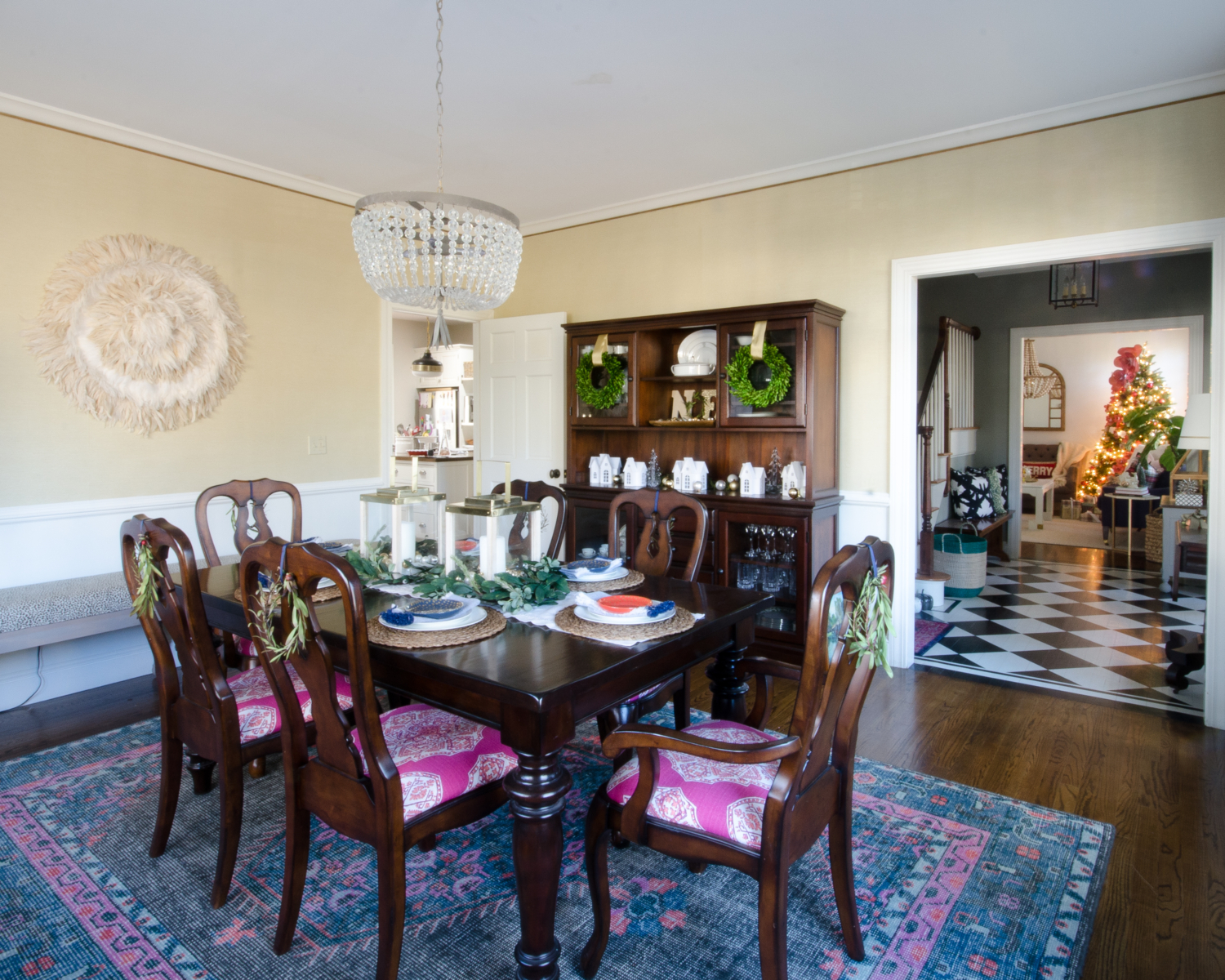 Christmas dining room with boxwood wreaths and a Christmas village scene