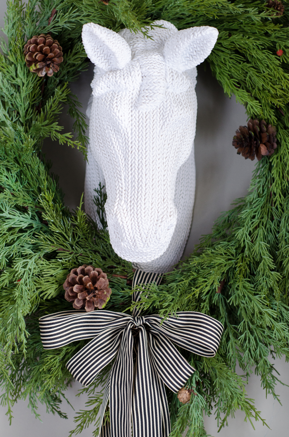 Classic Christmas entryway with greenery, twinkle lights, cable knit stockings, and more! So much inspiration!!