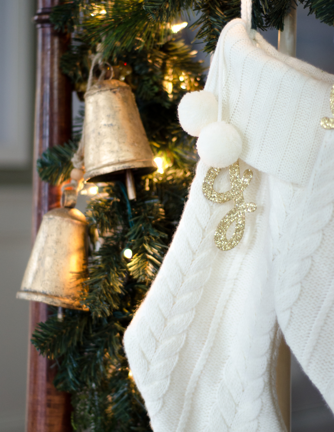 Classic Christmas entryway with greenery, twinkle lights, cable knit stockings, and more! So much inspiration!!