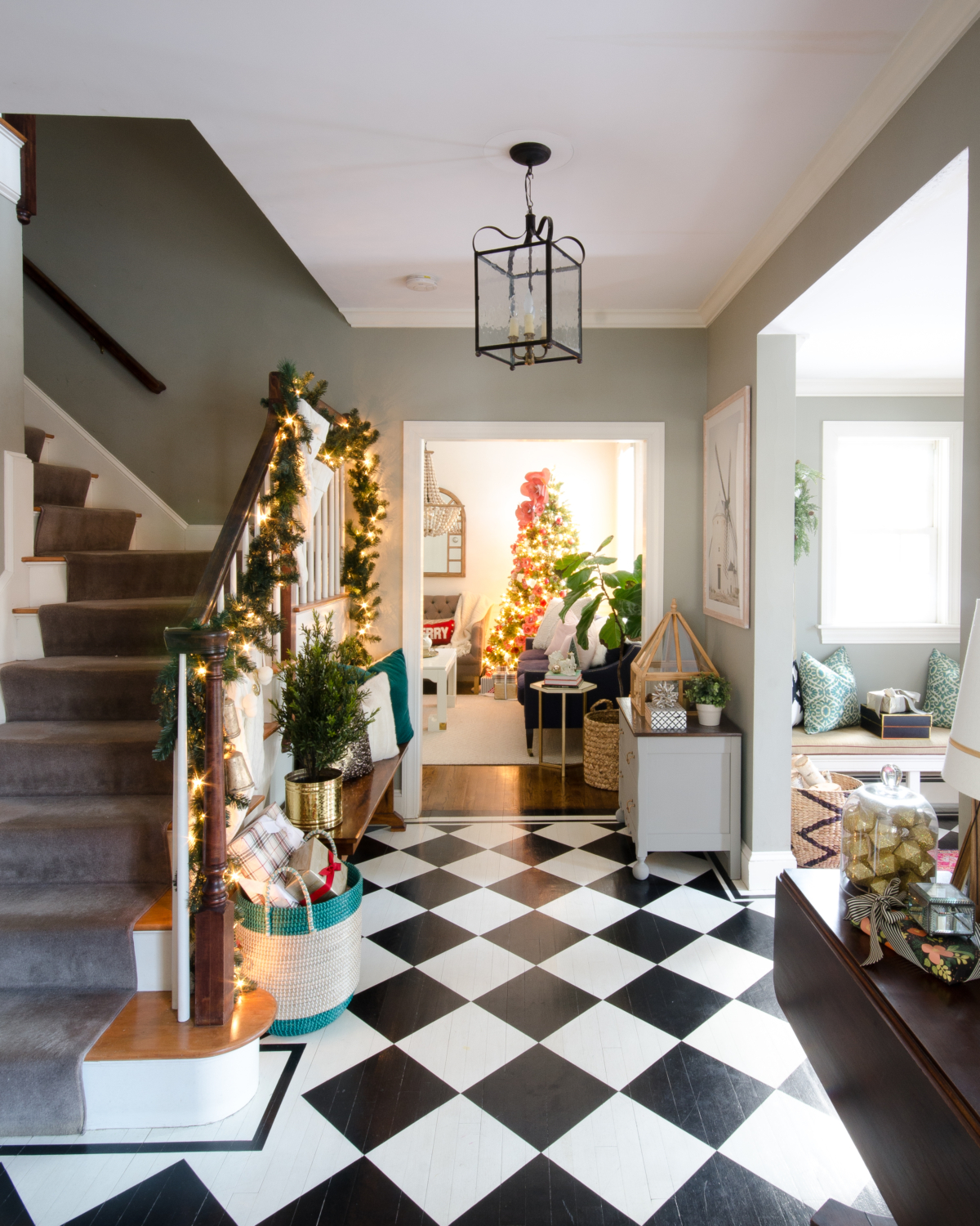 Classic Christmas entryway with greenery, twinkle lights, cable knit stockings, and more! So much inspiration!!