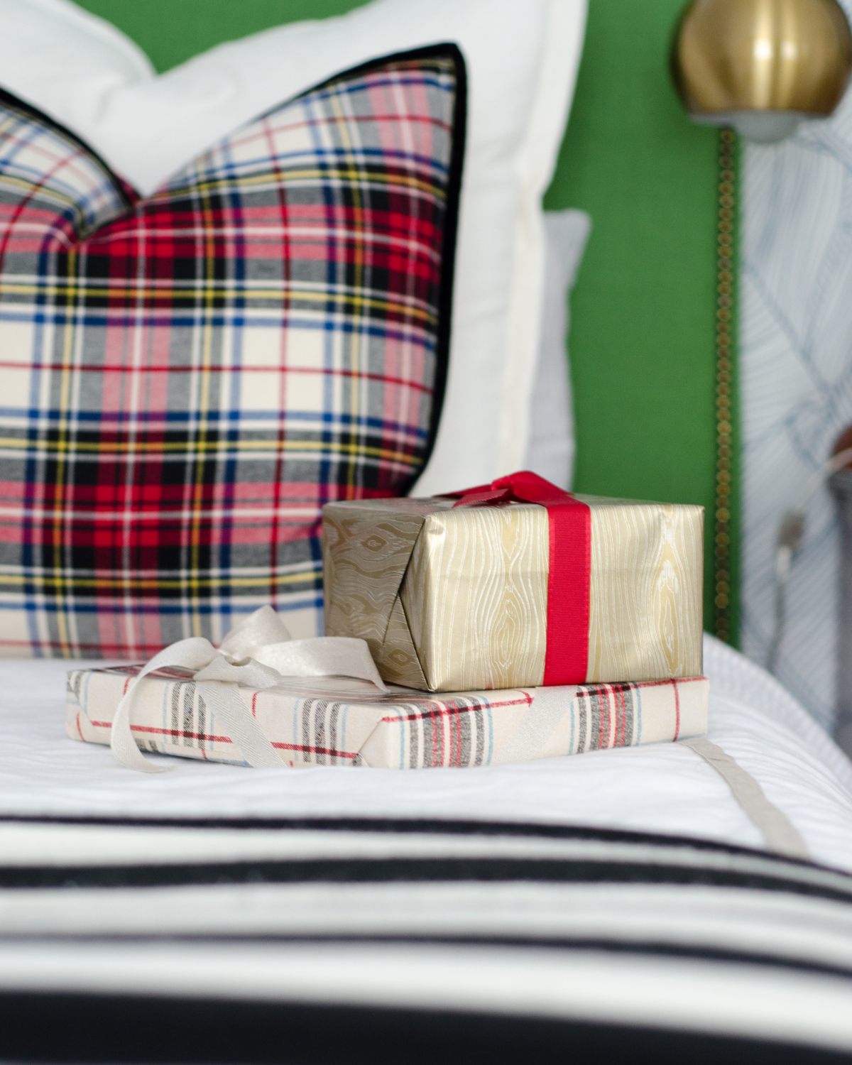 Classic Christmas guest room with custom DIY upholstered headboards, red plaid pillows, fresh greenery, and cute, quirky accents. Perfect way to make Christmas guest feel at home!