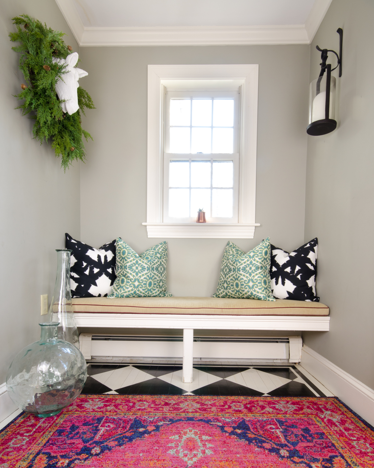 A charming, fresh entryway design featuring black and white, deep pink, and teal blue accents.