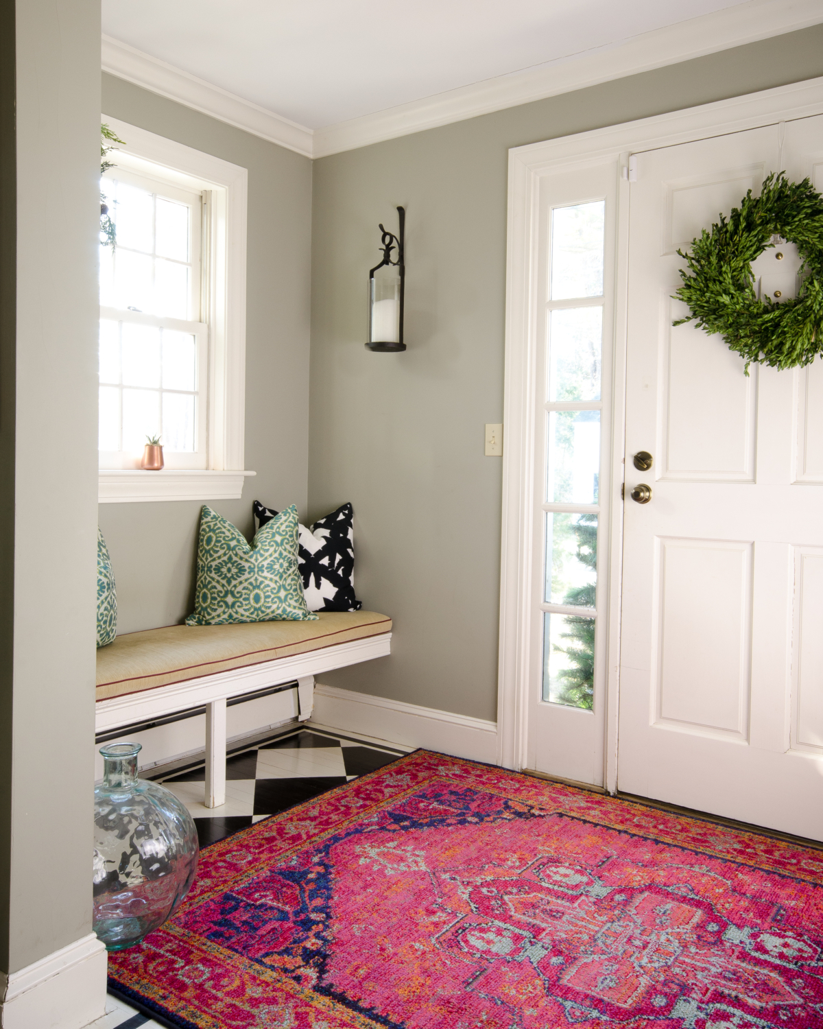 A charming, fresh entryway design featuring black and white, deep pink, and teal blue accents.