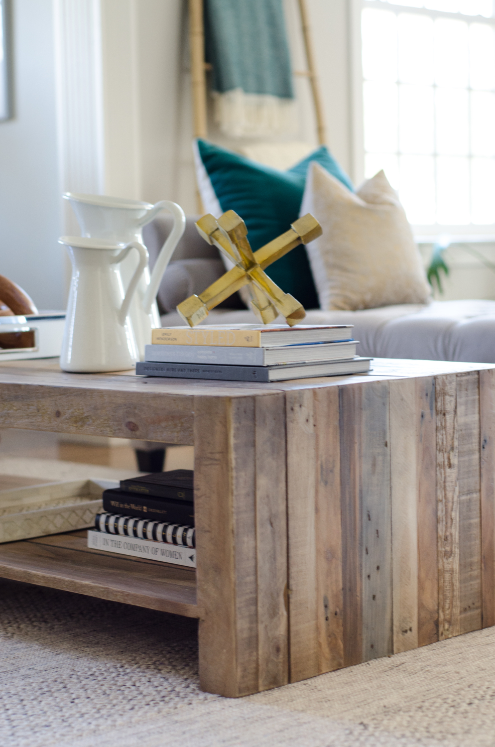 A stylish family room that's both chic and family-friendly featuring neutral furniture and thoughtful pops of color. Features an oversized English roll arm sofa, a tufted daybed / backless sofa that divides the room into two seating areas, and reclaimed wood accent tables to balance traditional and rustic.