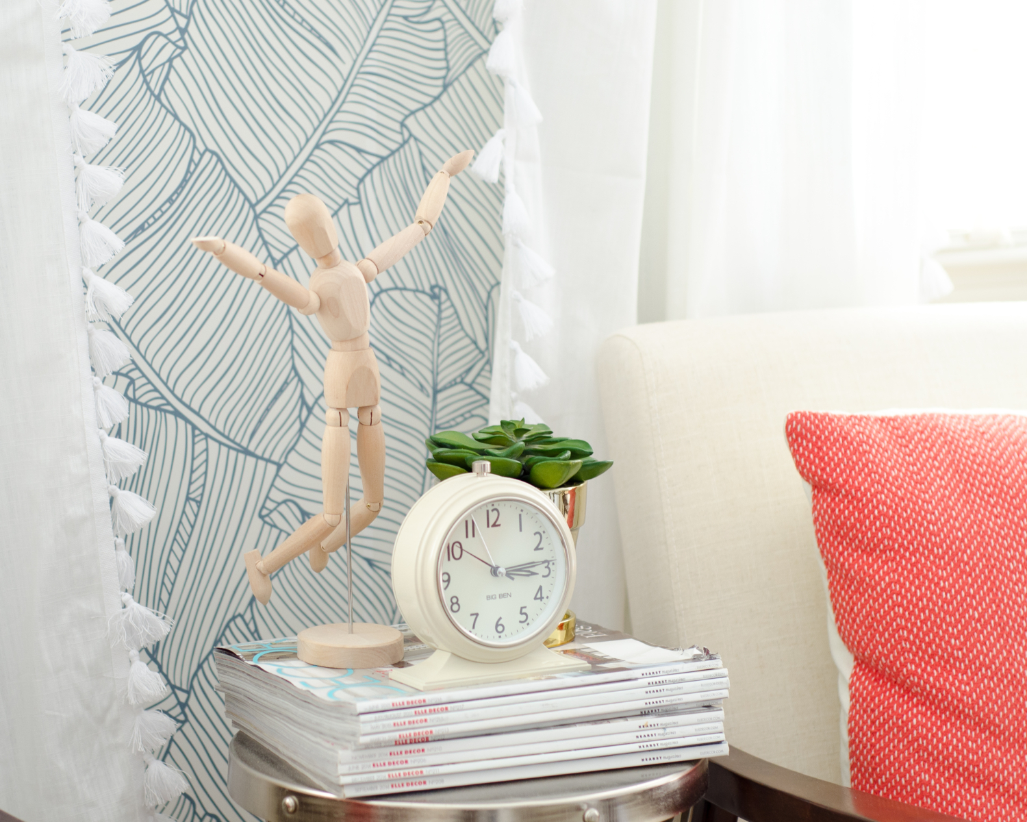 Gorgeous guest room with palm wallpaper, green linen headboards, mustard yellow leather benches, and accents of blush and coral