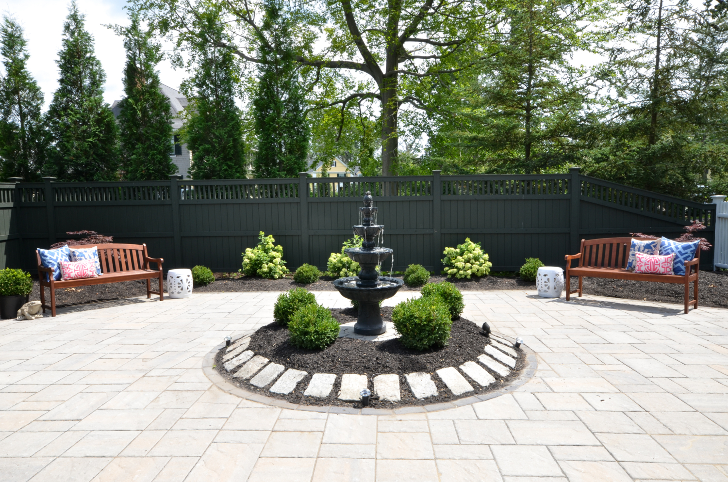 Custom paver patio with a fountain at the center, classic outdoor living space ideas for decorating your deck or patio