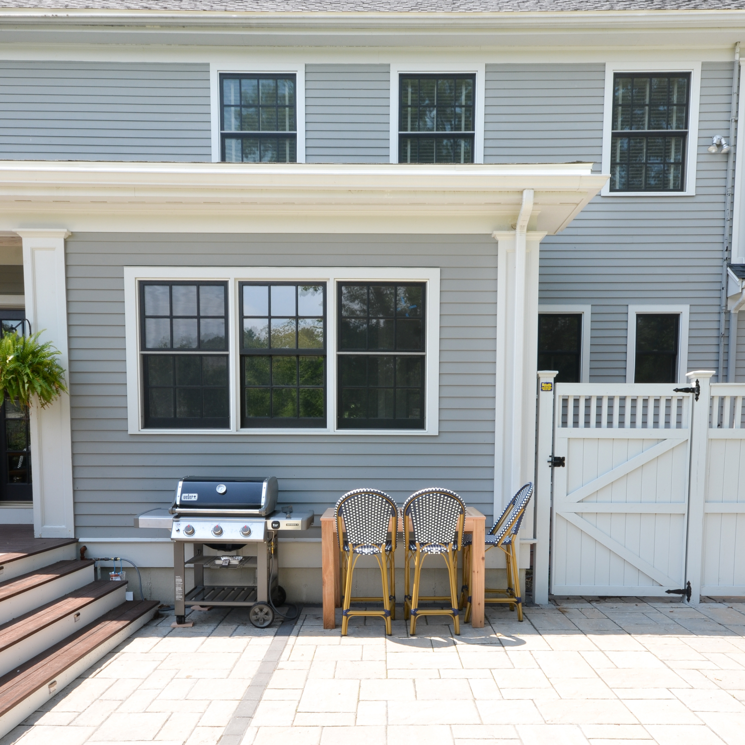 Amazing backyard landscaping makeover that includes a Trex deck, a paver patio with gas firepit, and a paver patio with a fountain and benches. So much outdoor inspiration!