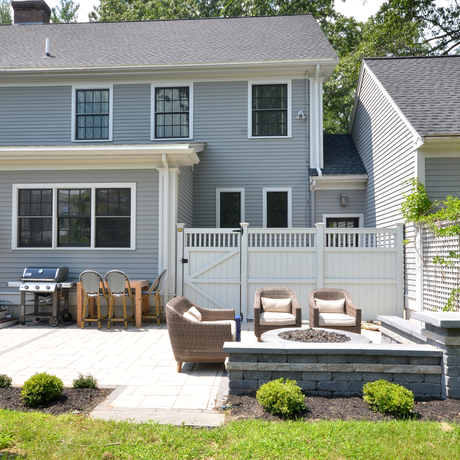 Amazing backyard landscaping makeover that includes a Trex deck, a paver patio with gas firepit, and a paver patio with a fountain and benches. So much outdoor inspiration!