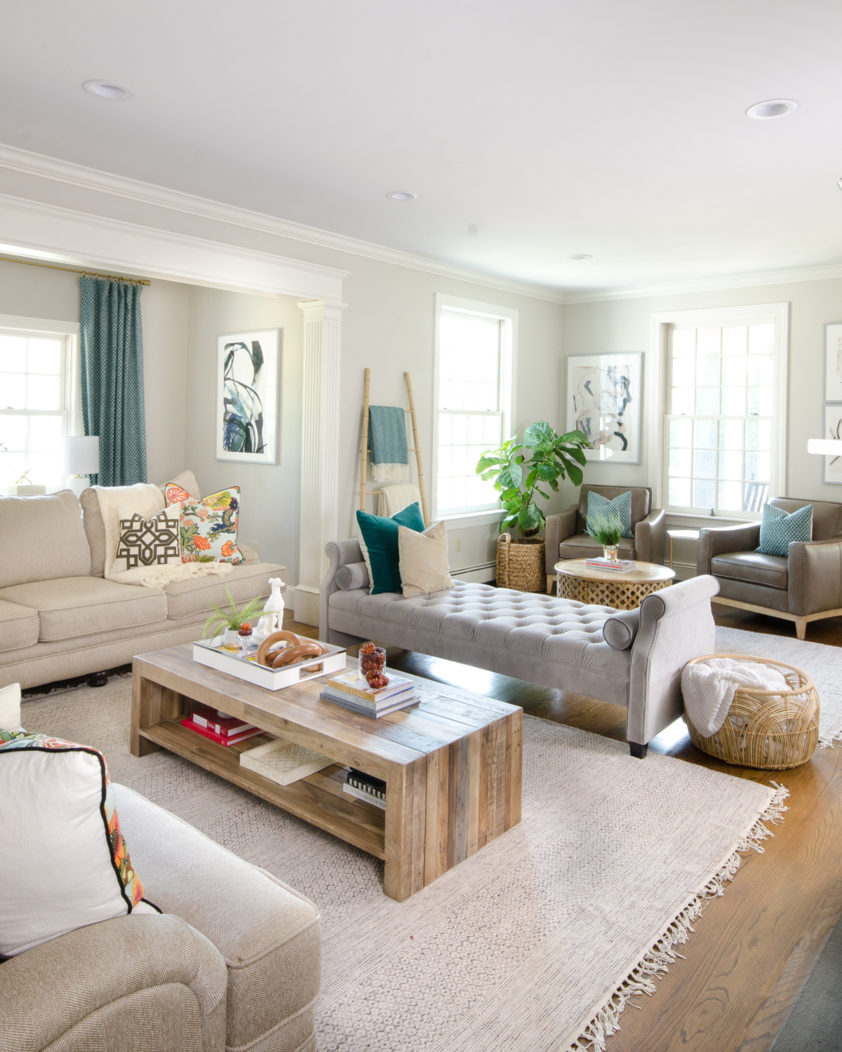 Beautiful neutral family room with pops of color and wood accents. Backless sofa divides the long room into two seating areas. Nice mix of traditional and rustic styles. 