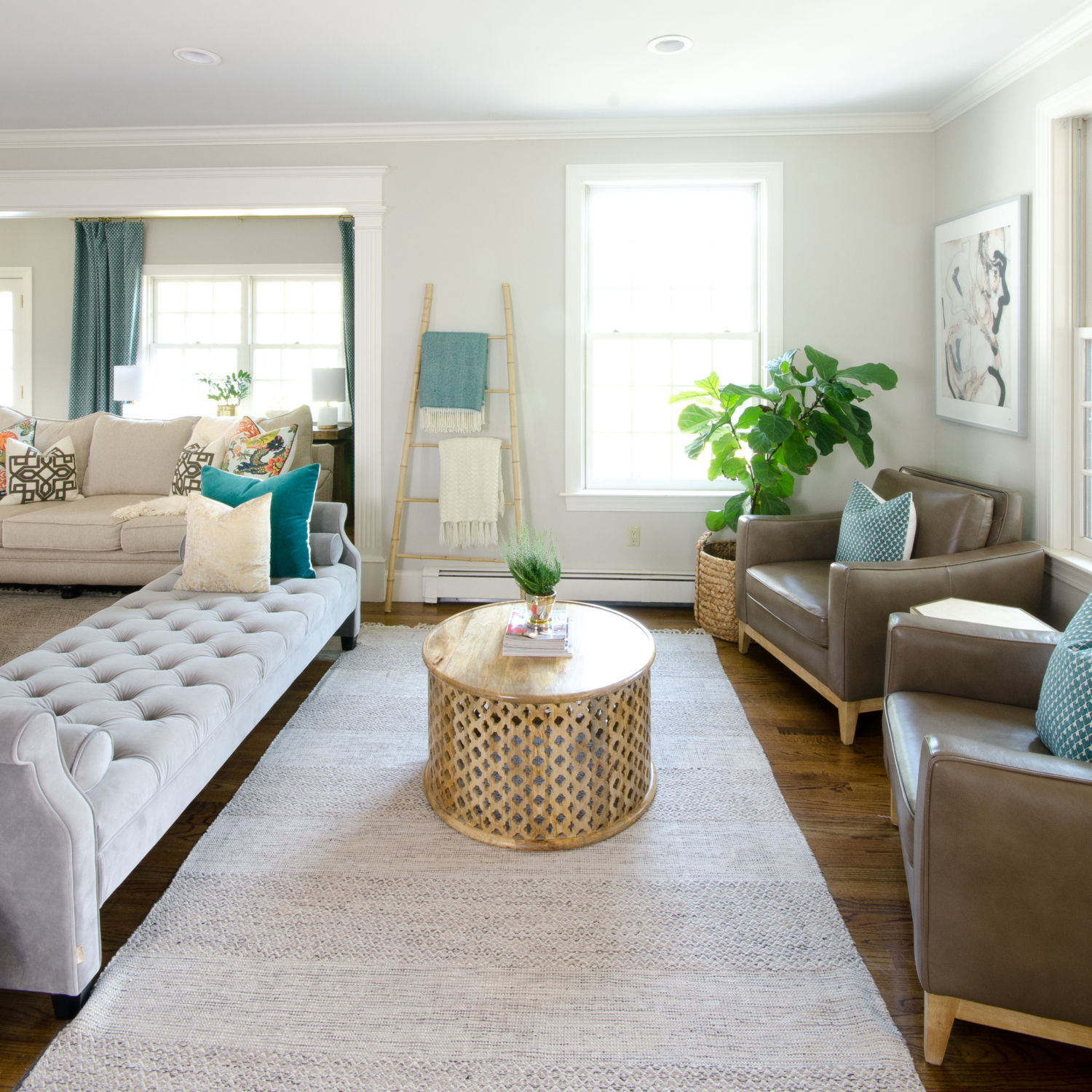 Beautiful neutral family room with pops of color and wood accents. Backless sofa divides the long room into two seating areas. Nice mix of traditional and rustic styles. 