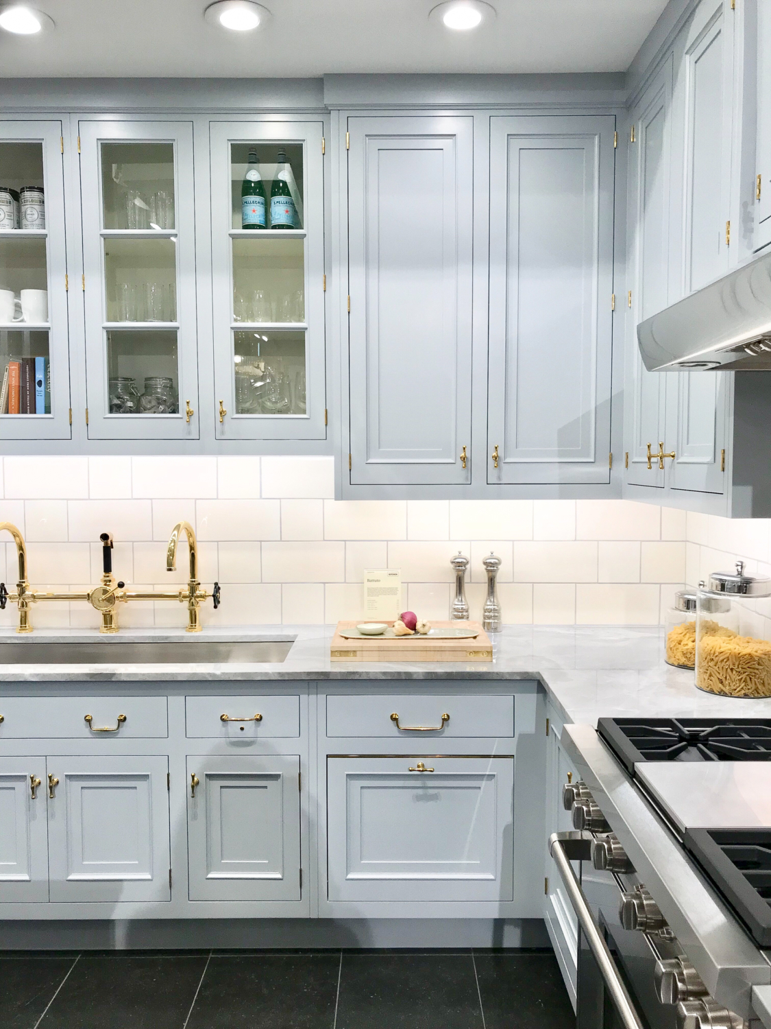 Grey kitchen cabinets with polished brass hardware