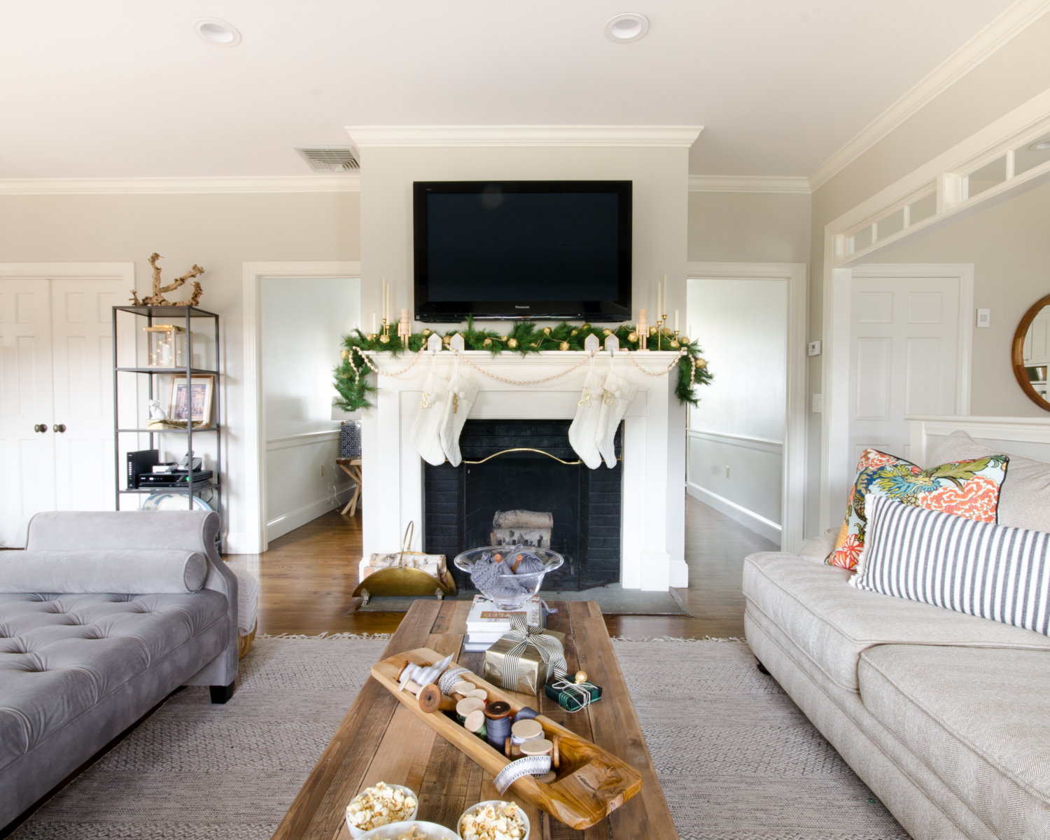 A simple and classic Christmas mantle with greenery, white cable knit stockings, nutcrackers, and gold accents. 2017 Holiday Housewalk