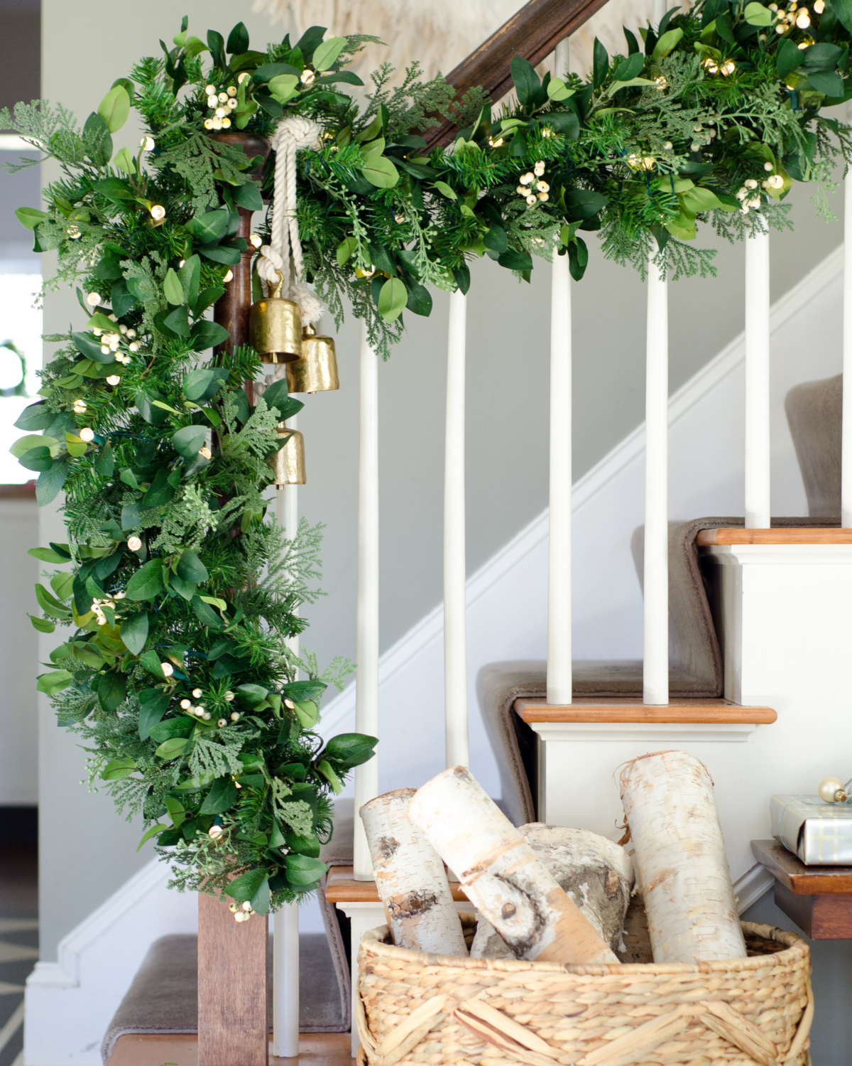 Classic Christmas entry with red, black, white, and greenery. Thick faux garland with white accents.