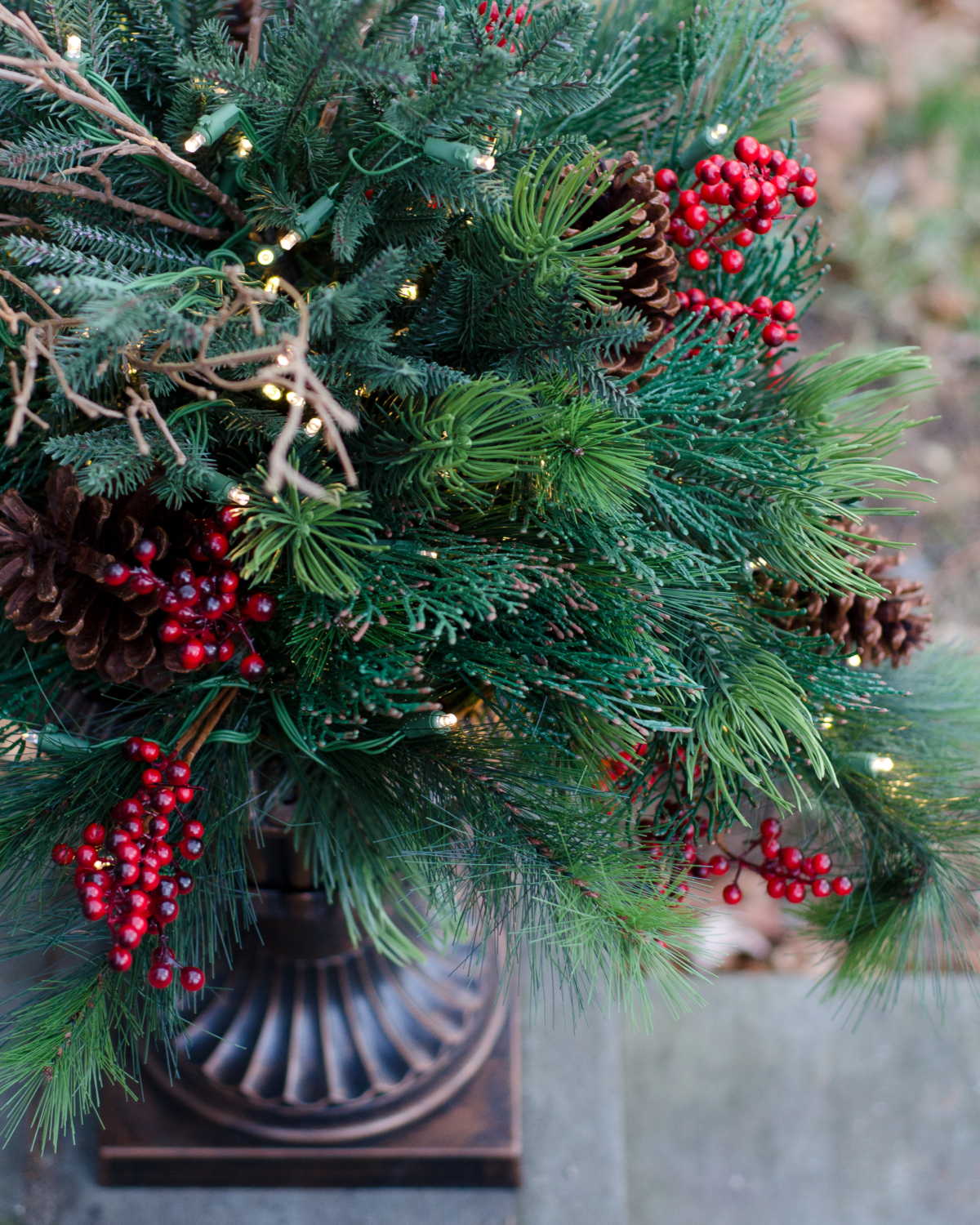 Classic Christmas front door with evergreen wreath and lush urn planters