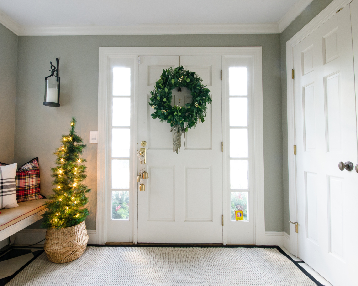 Classic Christmas entry with red, black, white, and greenery