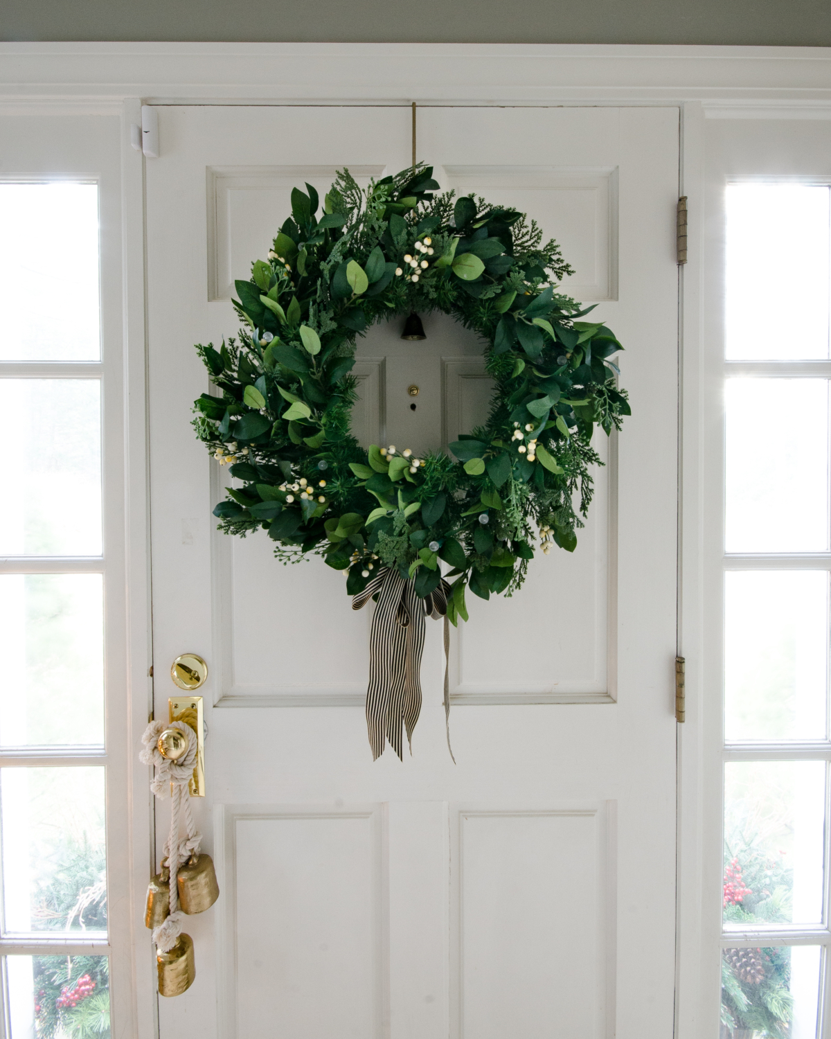 Classic Christmas entry with red, black, white, and greenery