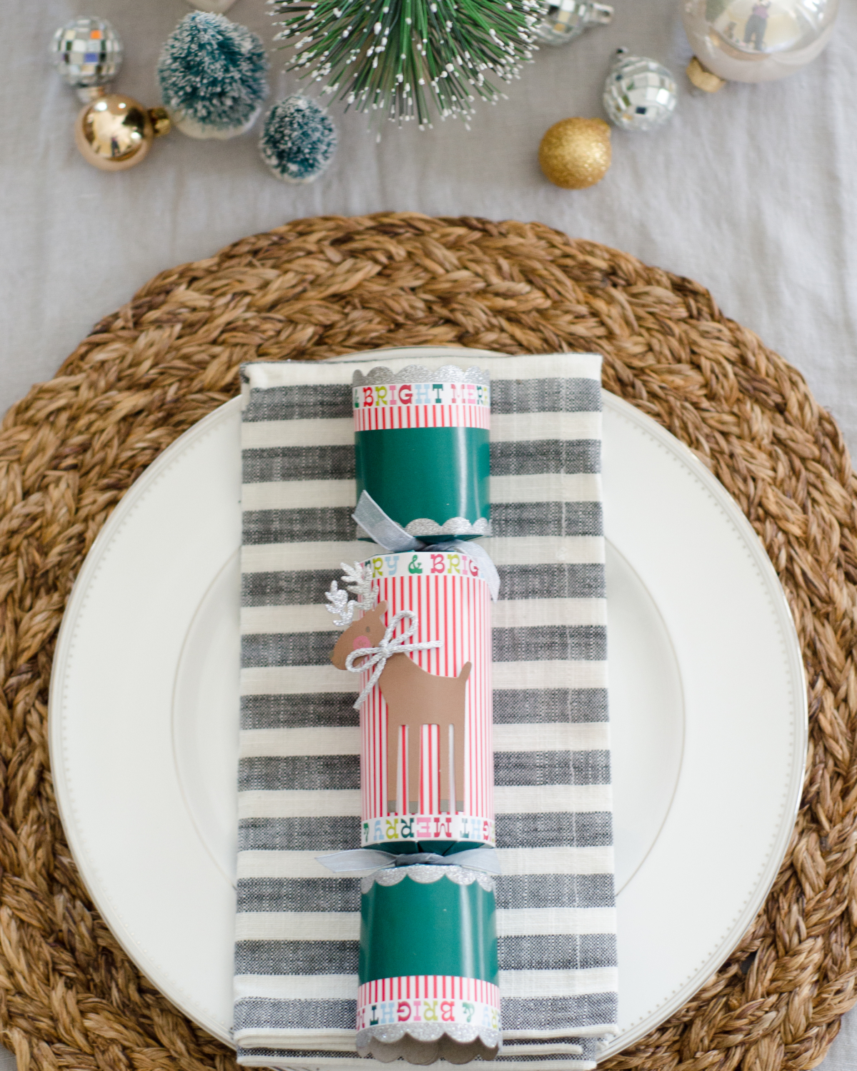 A simple and classic Christmas dining room with ceramic houses and bottle brush trees used as a Christmas centerpiece idea.