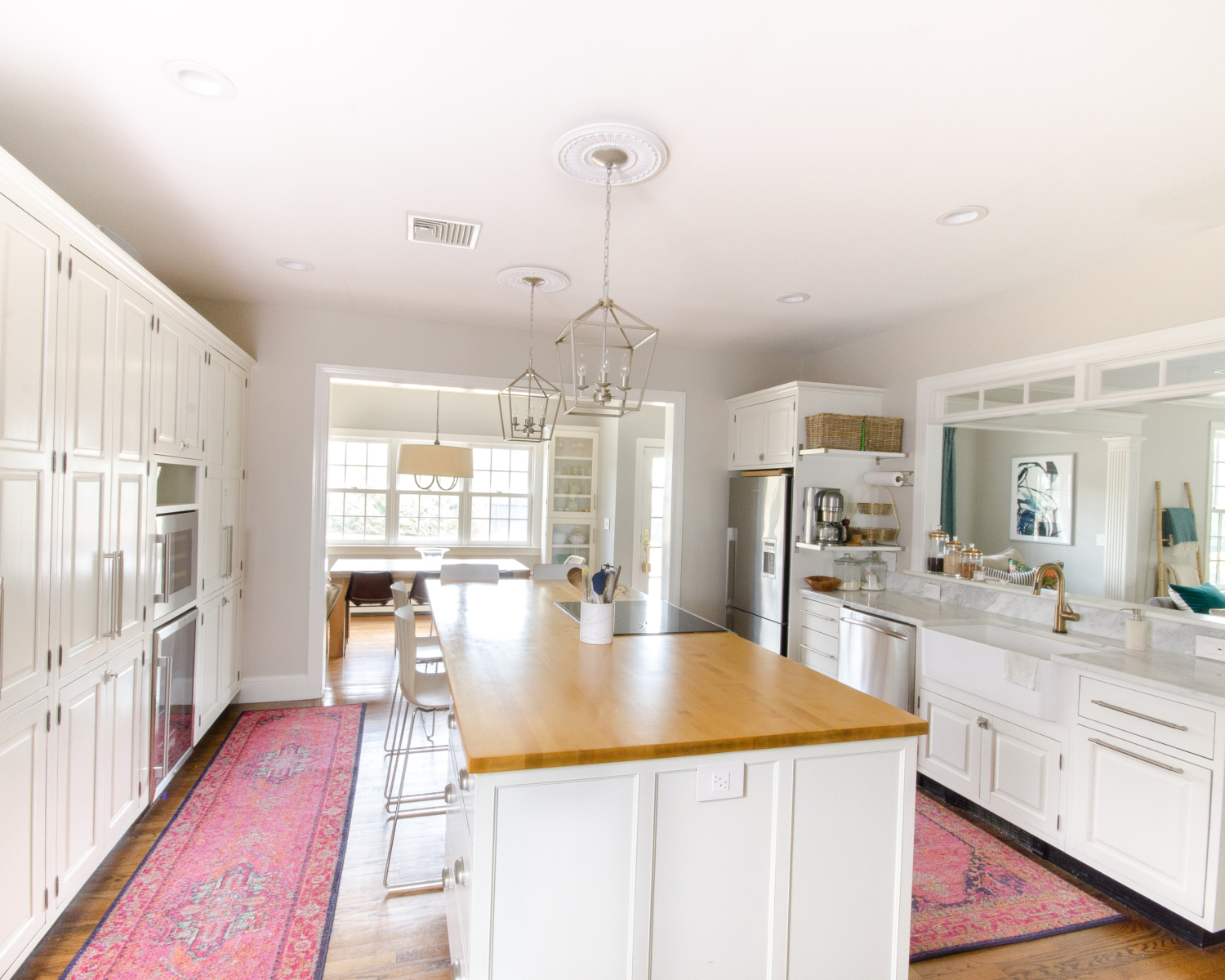 A classic white kitchen with lantern kitchen pendants and warm wood accents. Beautiful mix of traditional and modern in this family-friendly kitchen.