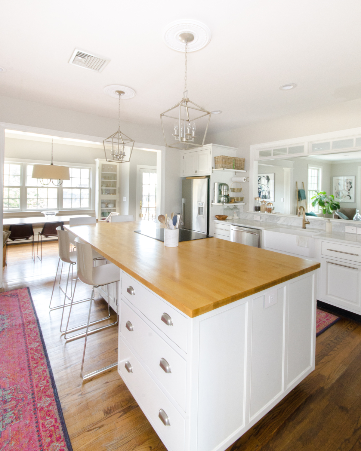 A classic white kitchen with lantern kitchen pendants and warm wood accents. Beautiful mix of traditional and modern in this family-friendly kitchen.