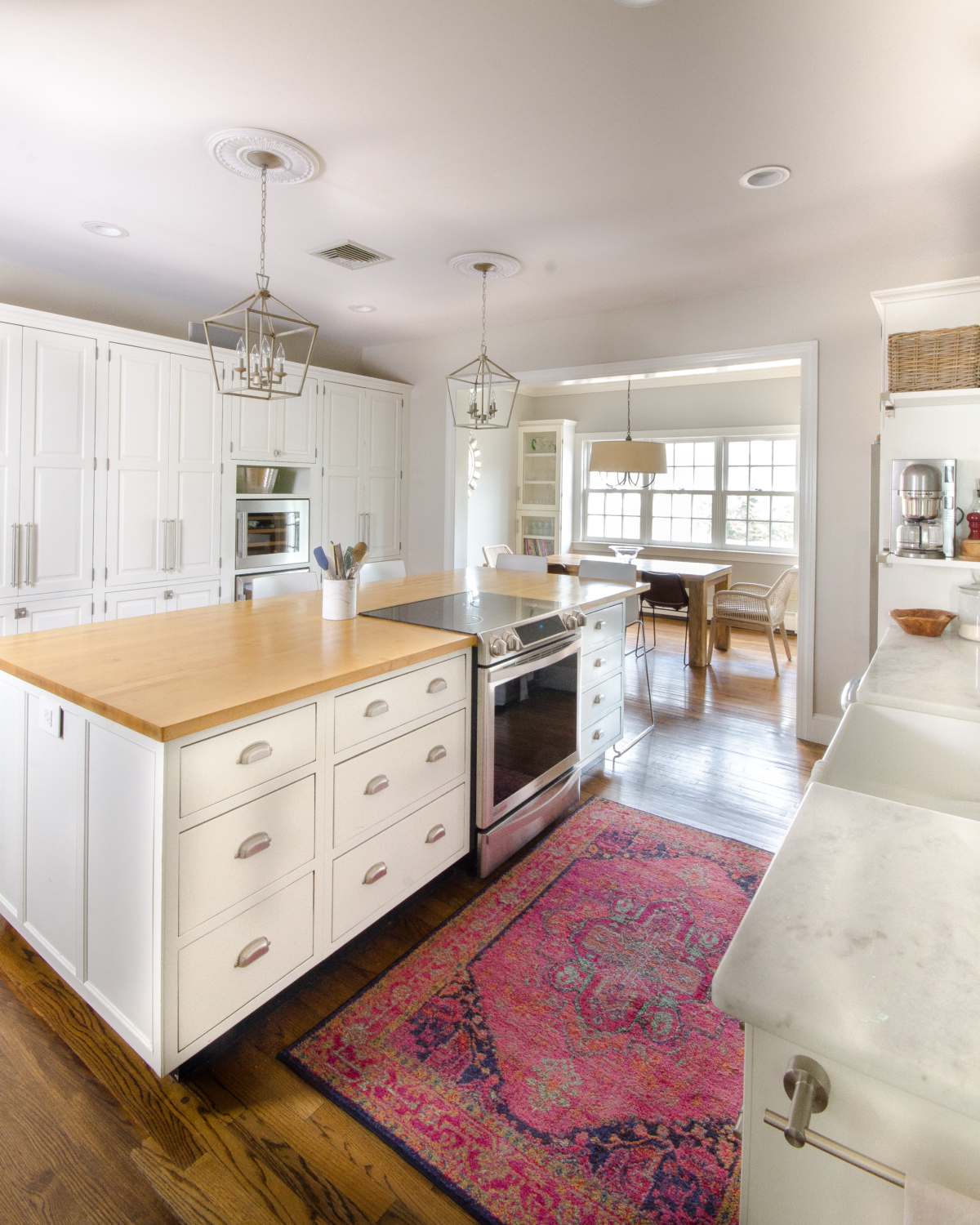 A classic white kitchen with lantern kitchen pendants and warm wood accents. Beautiful mix of traditional and modern in this family-friendly kitchen.