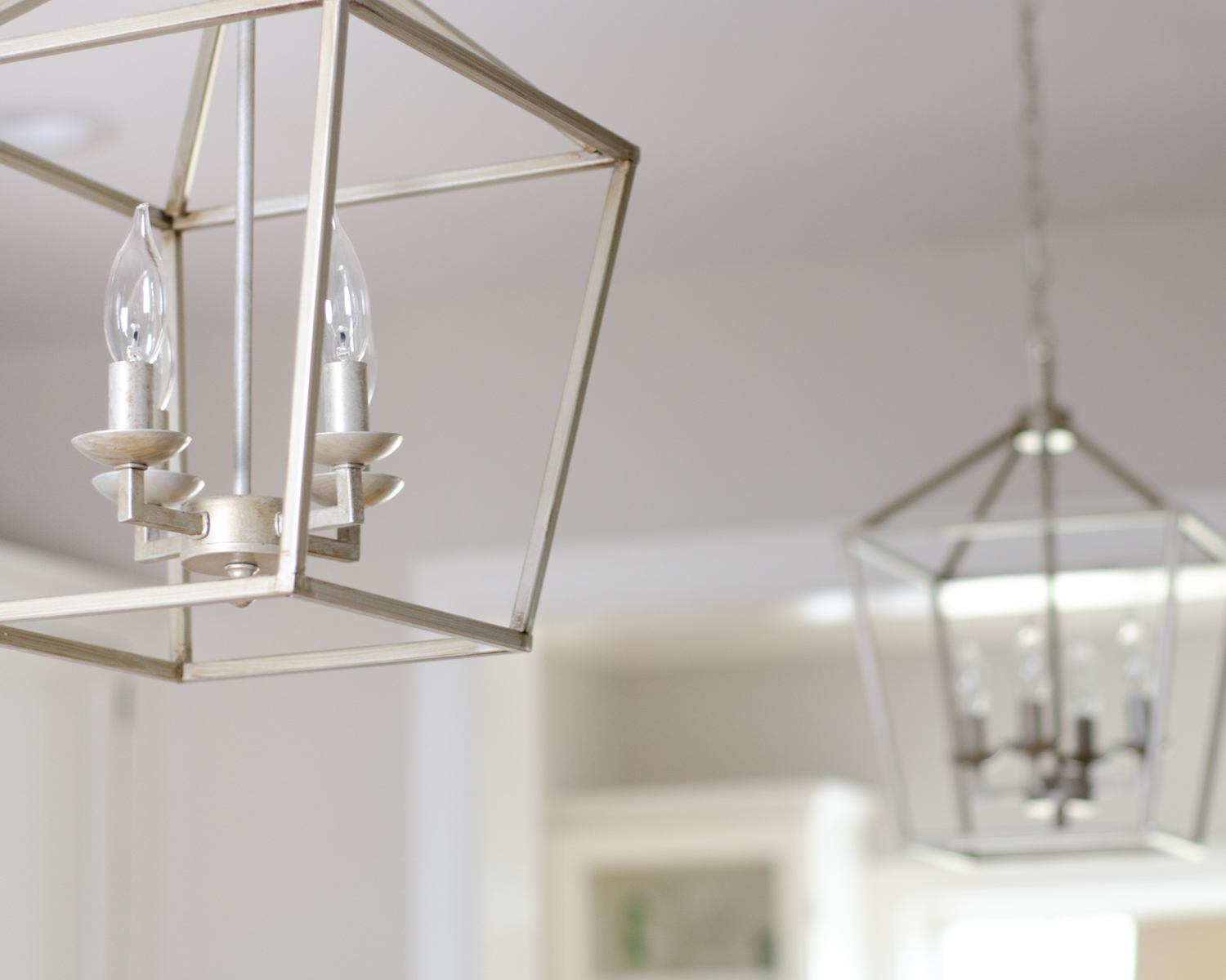 A classic white kitchen with lantern kitchen pendants and warm wood accents. Beautiful mix of traditional and modern in this family-friendly kitchen.