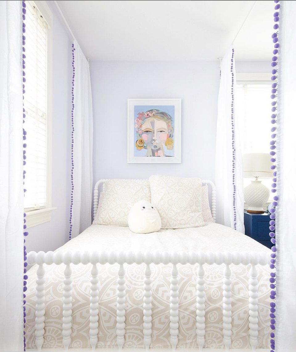 Purple and white girl's bedroom with a classic Jenny Lind spindle bed.