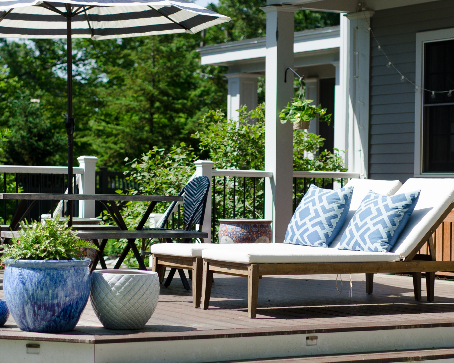 Gorgeous deck space with lush plantings, dining space, and lounge chairs.