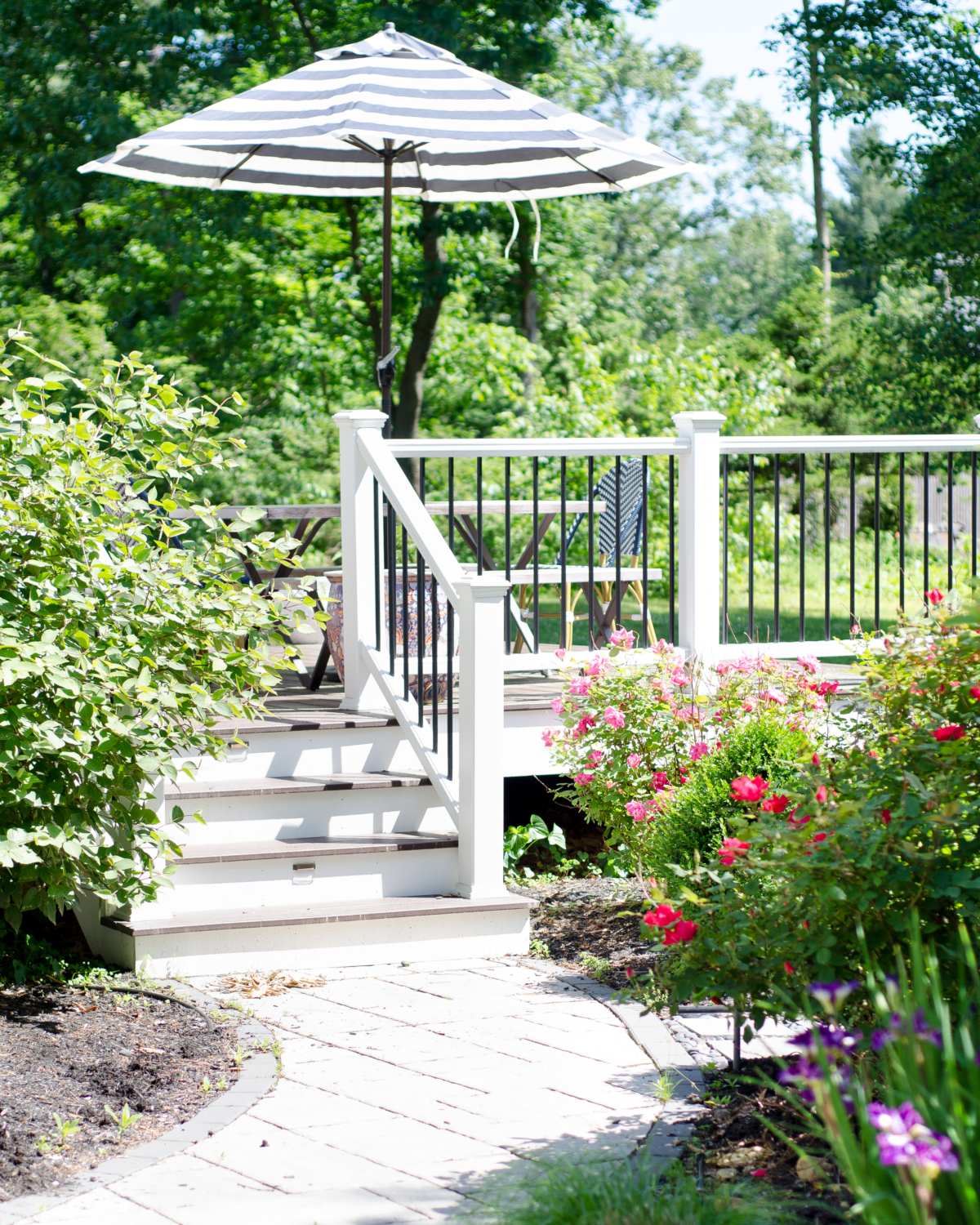 Gorgeous deck space with lush plantings, dining space, and lounge chairs.