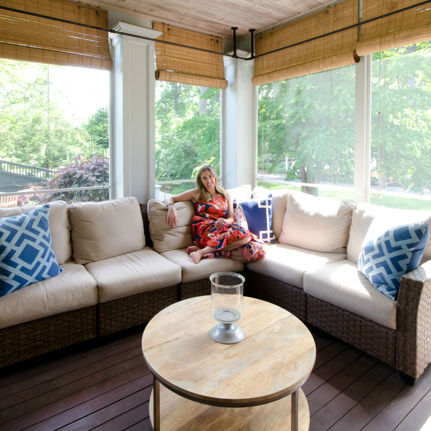 Screened porch space with dining and seating areas, a wood planked ceiling, and built in fireplace.