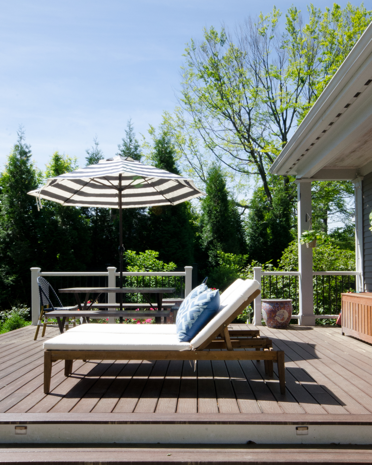 Gorgeous deck space with lush plantings, dining space, and lounge chairs.