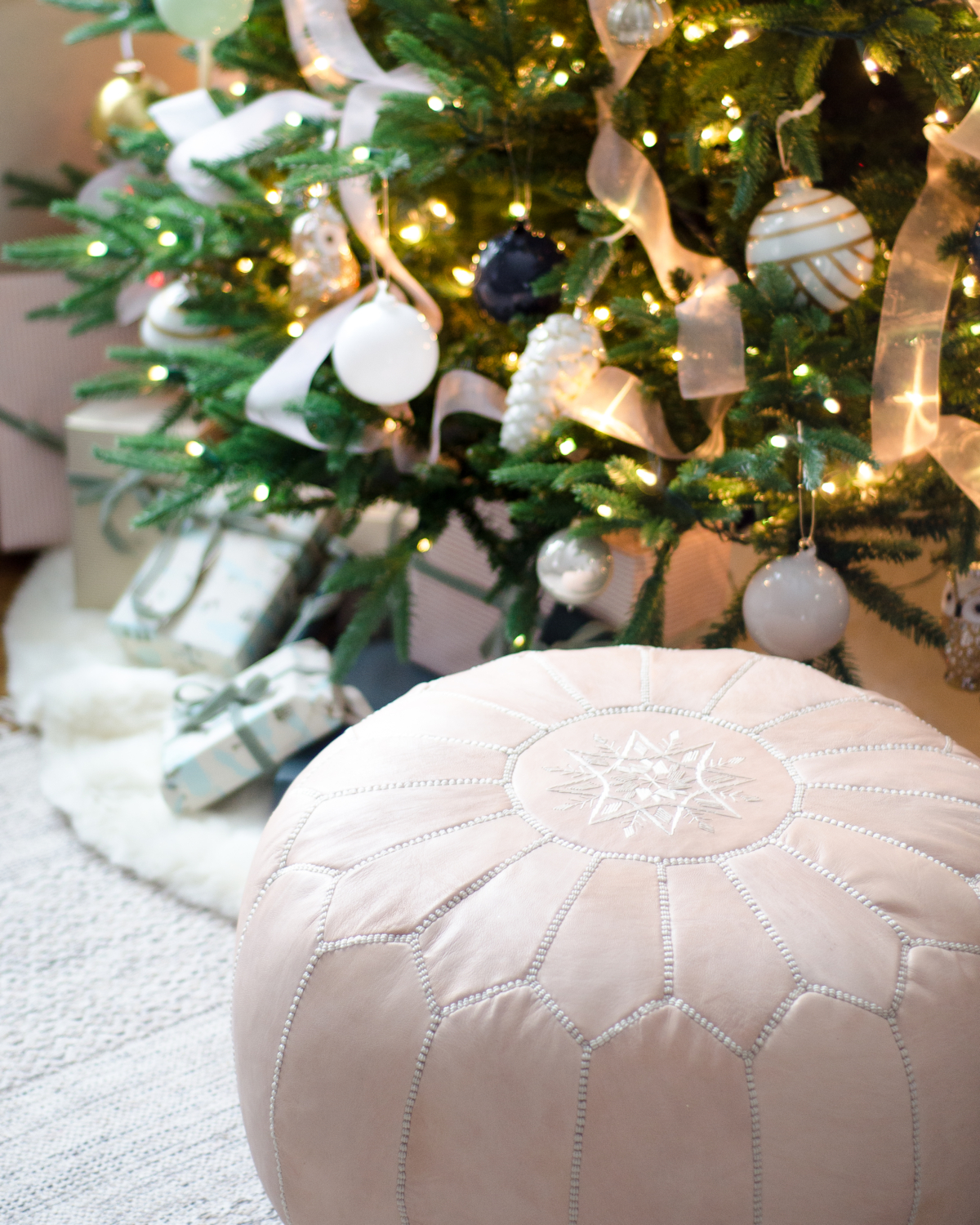 Christmas tree decorated in blush pink, deep teal, white, gold, and navy blue.